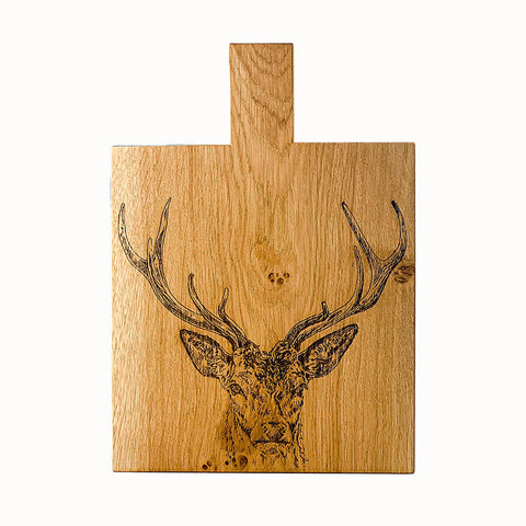 Light brown wooden stag prince oak paddle cutting board with laser engraved deer head and top handle medium size