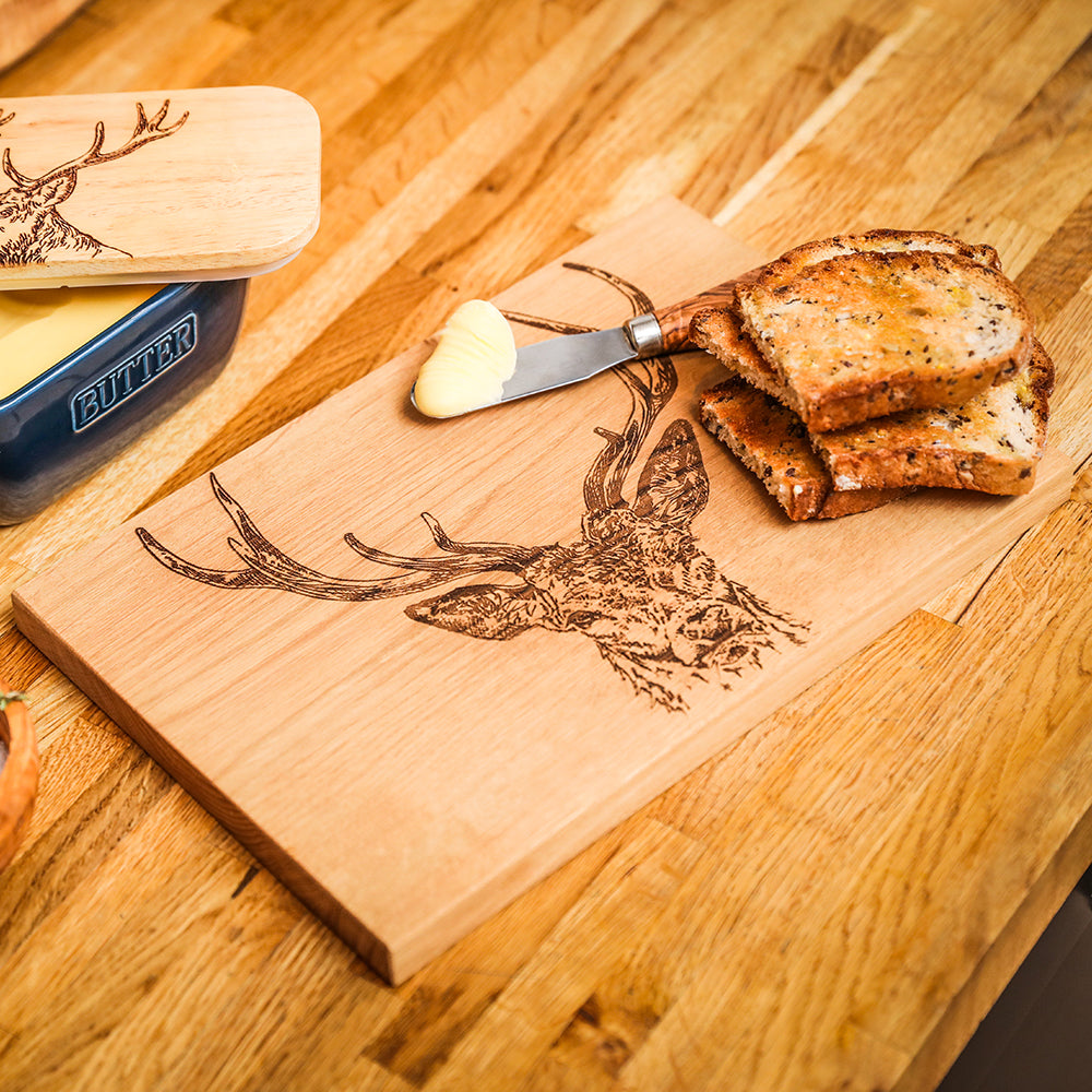 Light-colored stag prince oak serving and cheese board with detailed engraved deer head design on wood