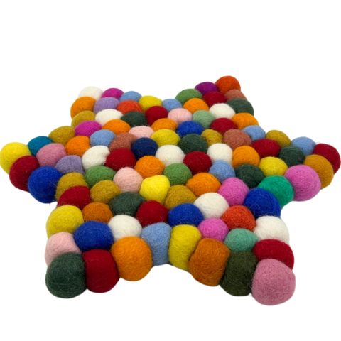 A vibrant star shape centre mat made of multicolour felt balls in red blue yellow green and pink hues