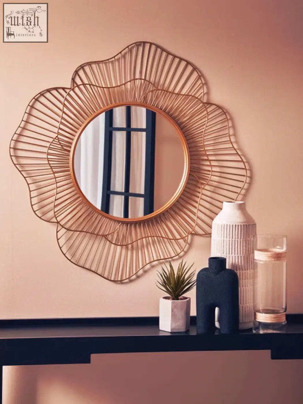 A gold-toned sunburst metal mirror with delicate frame design complements the sleek steen large vase glazed stoneware
