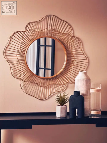 A gold-toned sunburst metal mirror with delicate frame design complements the sleek steen large vase glazed stoneware