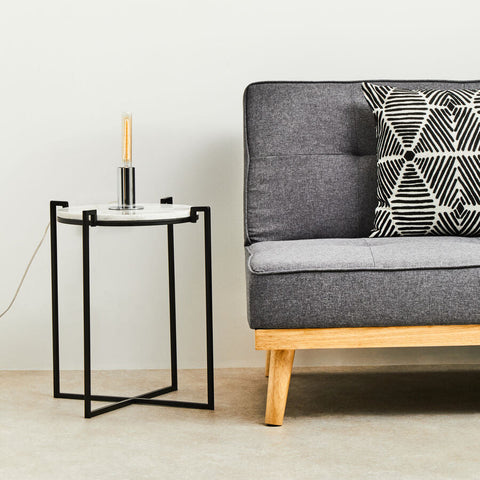 Black metal side table with white marble top and stockholm chrome finish table lamp with amber filament bulb