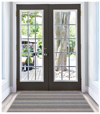 Dark gray double french doors with white-framed glass and gold hardware next to a stockholm grey clay washable mat