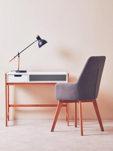 Gray upholstered chair with wooden legs paired with stockholm matte black table lamp on a matte black table
