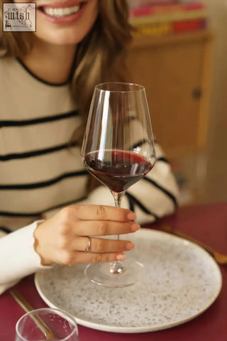 A clear elegant stolzle lausitz quattrophil red wine glass filled with deep red wine perfect for red wine glasses sets