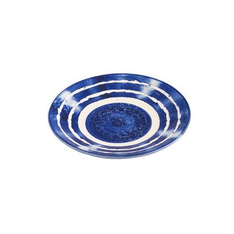 A hand painted stripe ceramic side plate with blue and white concentric stripes and a textured center