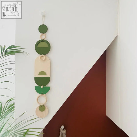 Stylish green geometric wall art with layered circular shapes connected by wooden rings for modern home decor
