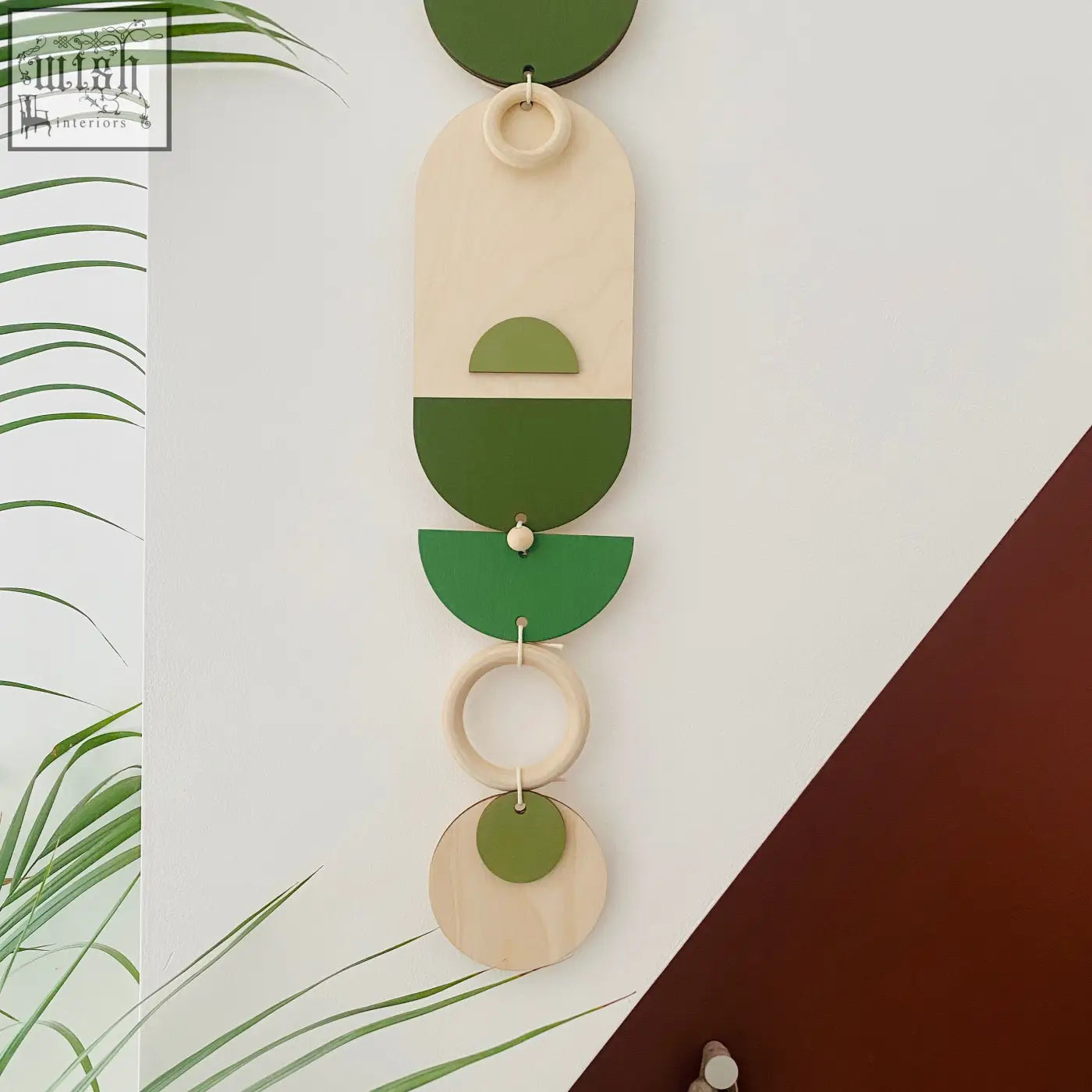 A modern green geometric wall art with layered wooden and painted circular shapes for stylish home decor