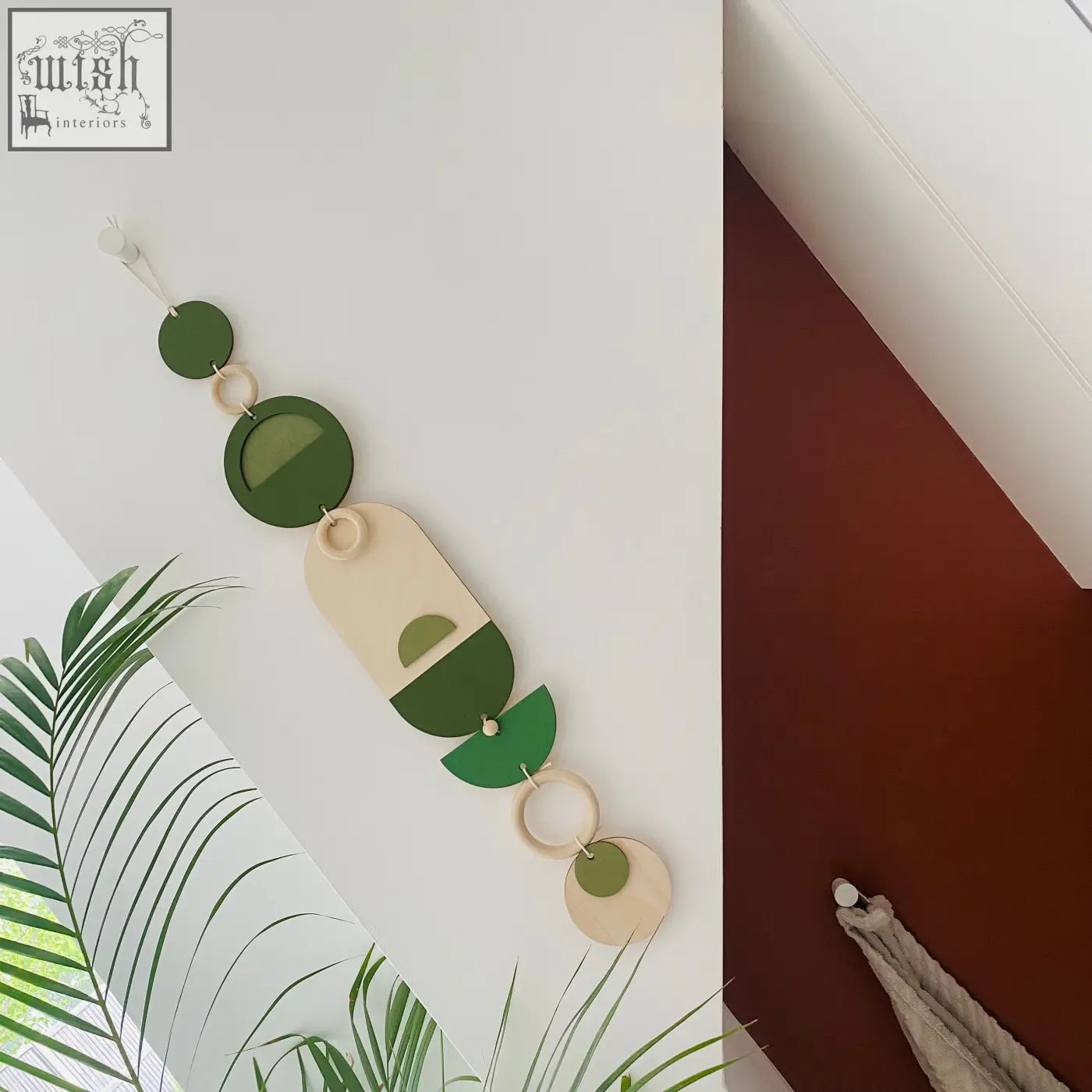 Stylish green geometric wall art with layered wooden circles and ovals connected by natural rings for modern decor