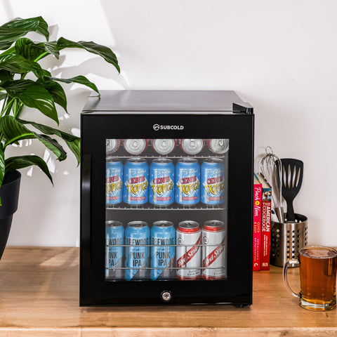 Black subcold ace50 beer fridge with glass door silver handle filled with assorted beer cans for chilling drinks