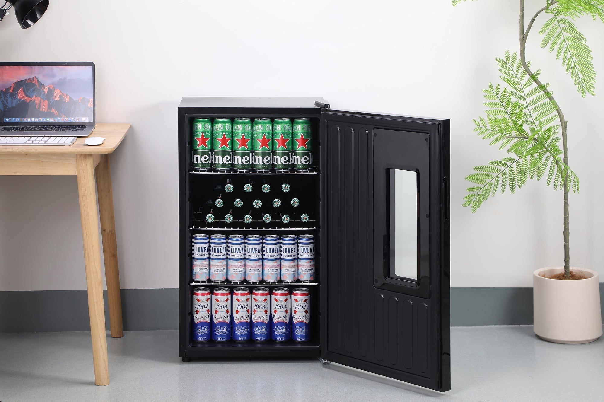 Black subcold apex95 beer fridge with glass door and shelves stocked with beer cans for chilling beverages