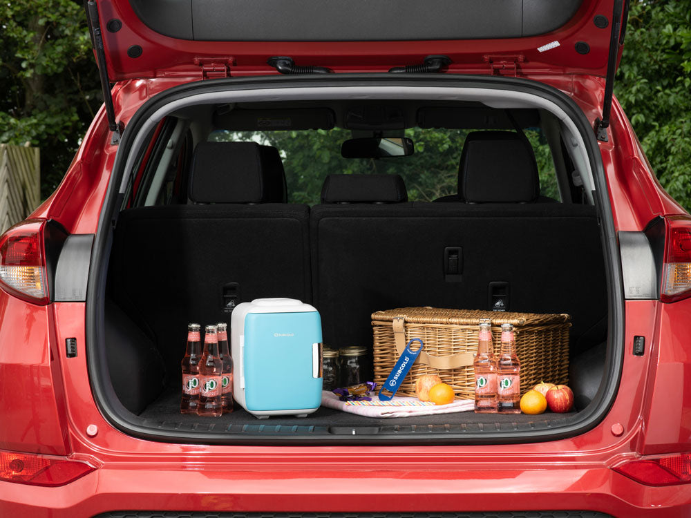 Light blue subcold classic 4l mini fridge with white top and black base in the trunk of a red suv mini fridge
