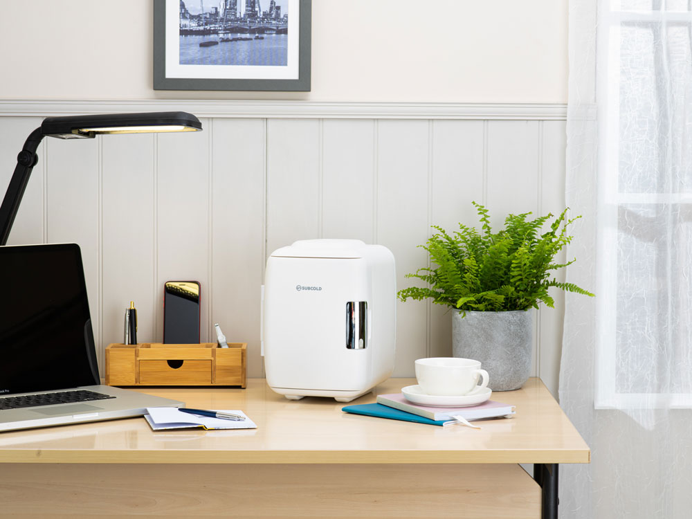 White Subcold classic 4L mini fridge with sleek modern design and silver handle accents mini cooler for personal use