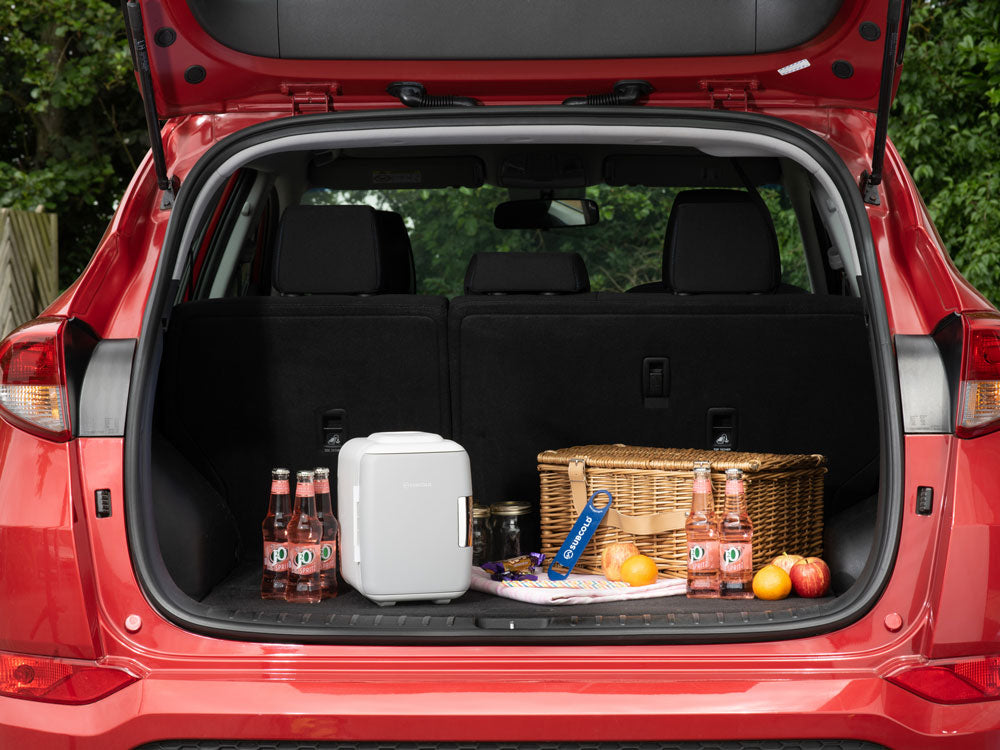 White compact portable mini fridge subcold classic 4l mini in a car trunk for easy travel and storage