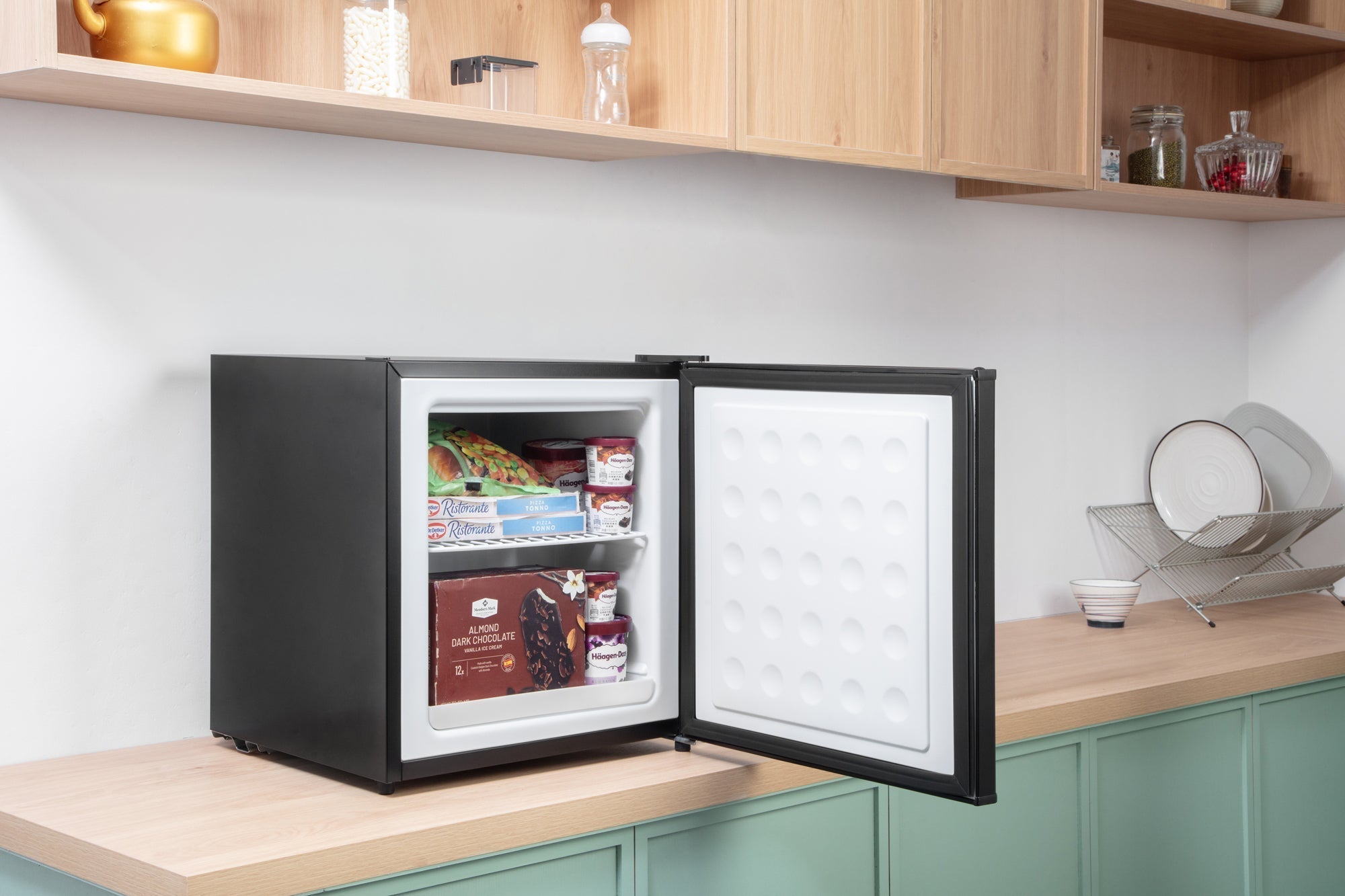 Black subcold eco35f mini freezer with white interior and textured door panel stocked with frozen food items