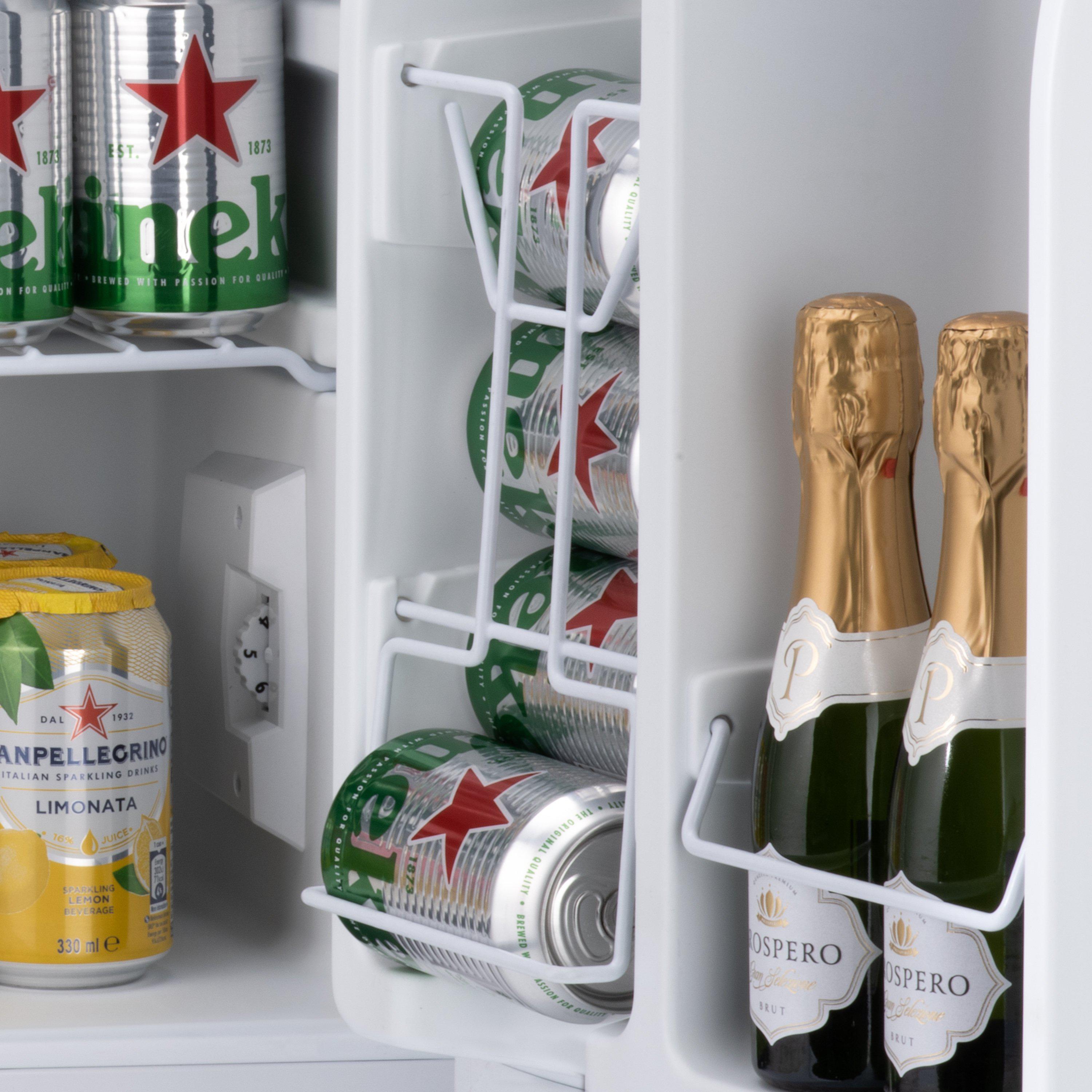 White wire rack in subcold eco75 table top fridge holding green silver heineken cans and gold prosecco bottles