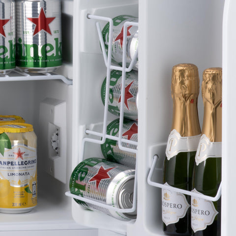 White wire rack in subcold eco75 table top fridge holding green silver heineken cans and gold prosecco bottles