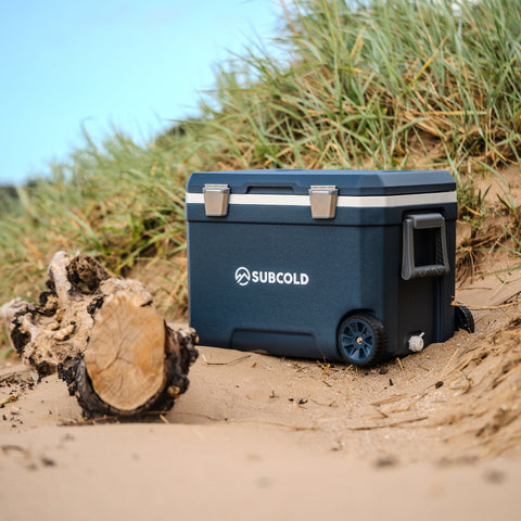 Navy blue subcold mobi45 cool box with silver latches wheels sturdy plastic body and white logo on the side