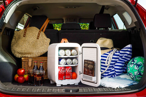 White subcold pro 10l mini fridge with open door showing canned drinks and chocolate bars inside compact 10l mini fridge