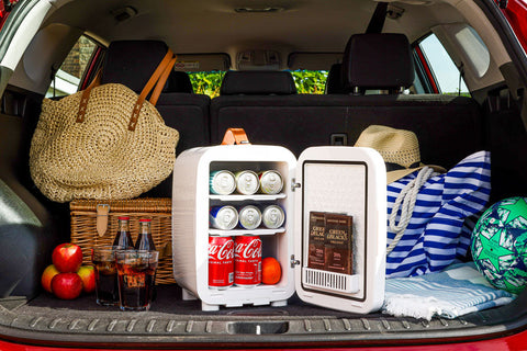White subcold pro 10l mini fridge with open door showing canned drinks and chocolate bars inside 10l mini fridge