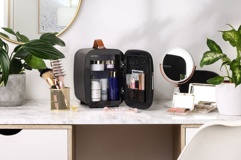 Black pro 4l mini fridge with brown leather handle and interior shelves storing beauty products in subcold pro 4l mini fridge