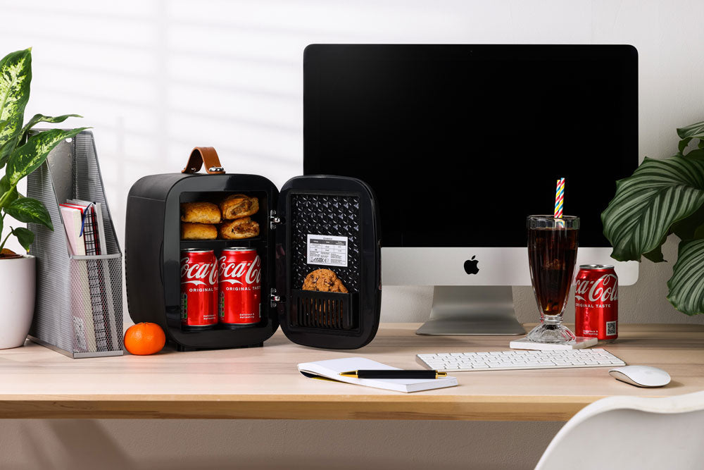 Black subcold pro 4l mini fridge with brown leather handle and interior shelves holding canned drinks and snacks