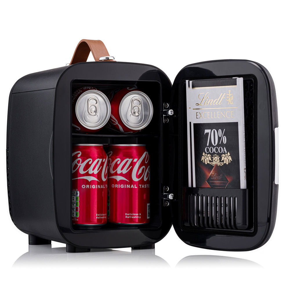 Black subcold pro 4l mini fridge with brown leather handle and shelves holding coca-cola cans and lindt chocolate bars