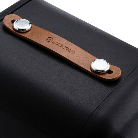 Brown leather key organizer with silver metal fasteners and surcold logo beside a Subcold pro 4L mini fridge