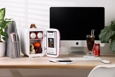Subcold Pro 4L mini fridge in pink and white with brown leather handle showing open door with drinks and fruit inside