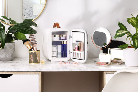 White subcold pro 4l mini fridge with brown leather handle and interior shelves holding beauty products