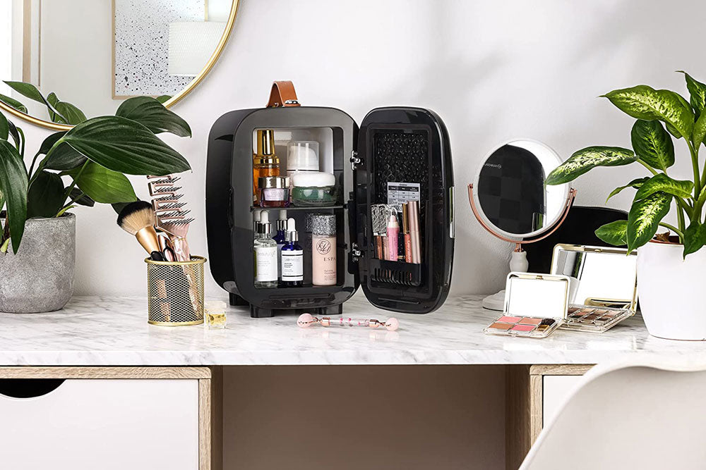 Black subcold pro 6l mini fridge with brown leather handle and removable shelf holding larger beauty products