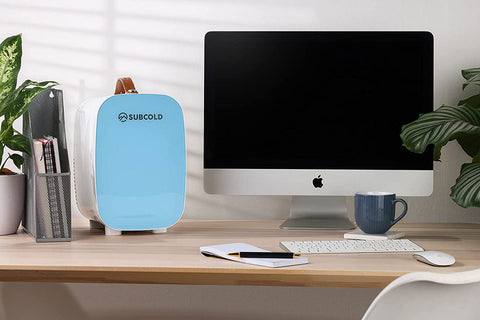 Light blue subcold pro 6l mini fridge with white base brown leather handle and removable shelf for larger items