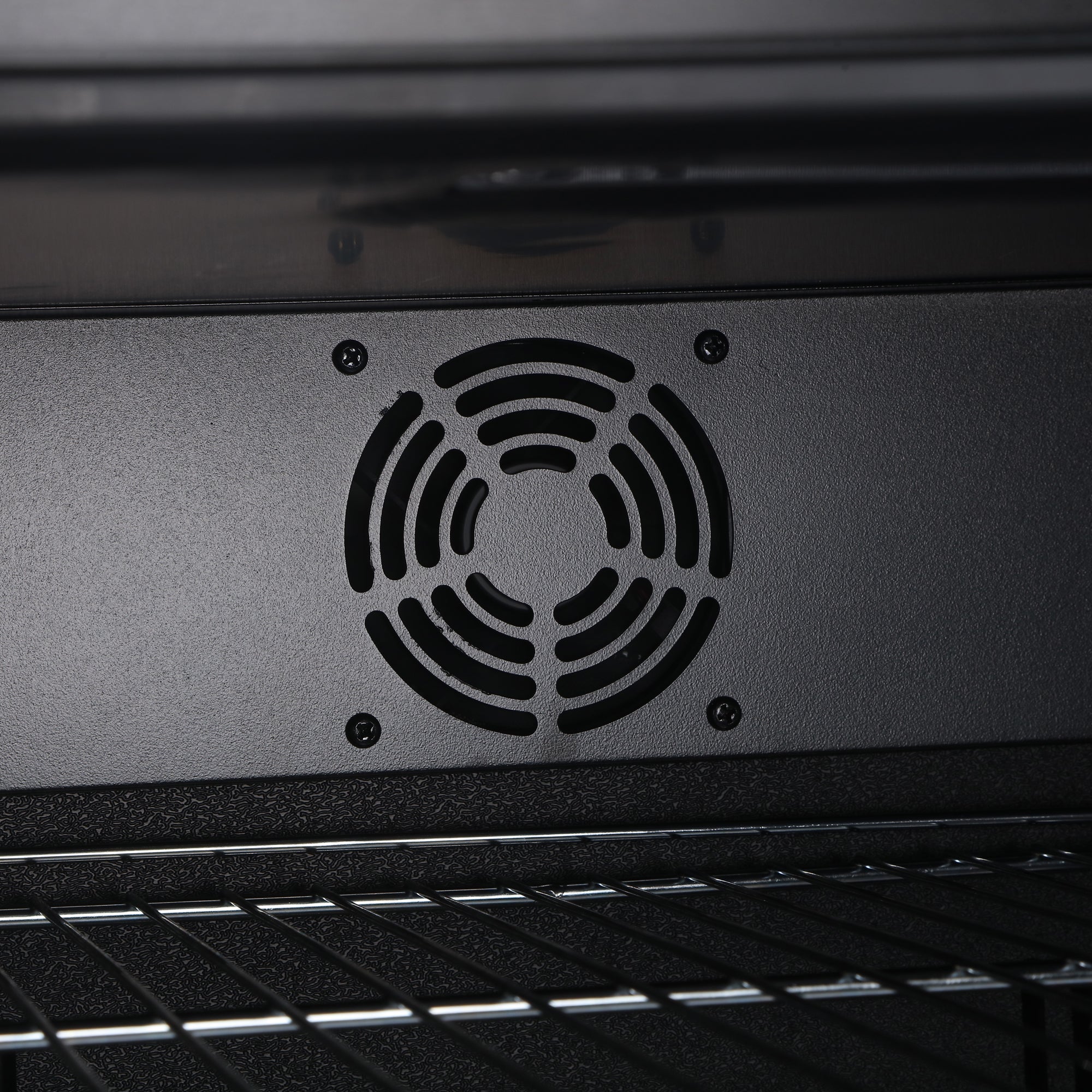 Black circular ventilation grille with concentric rings on matte metal panel at back of subcold super led beer fridge