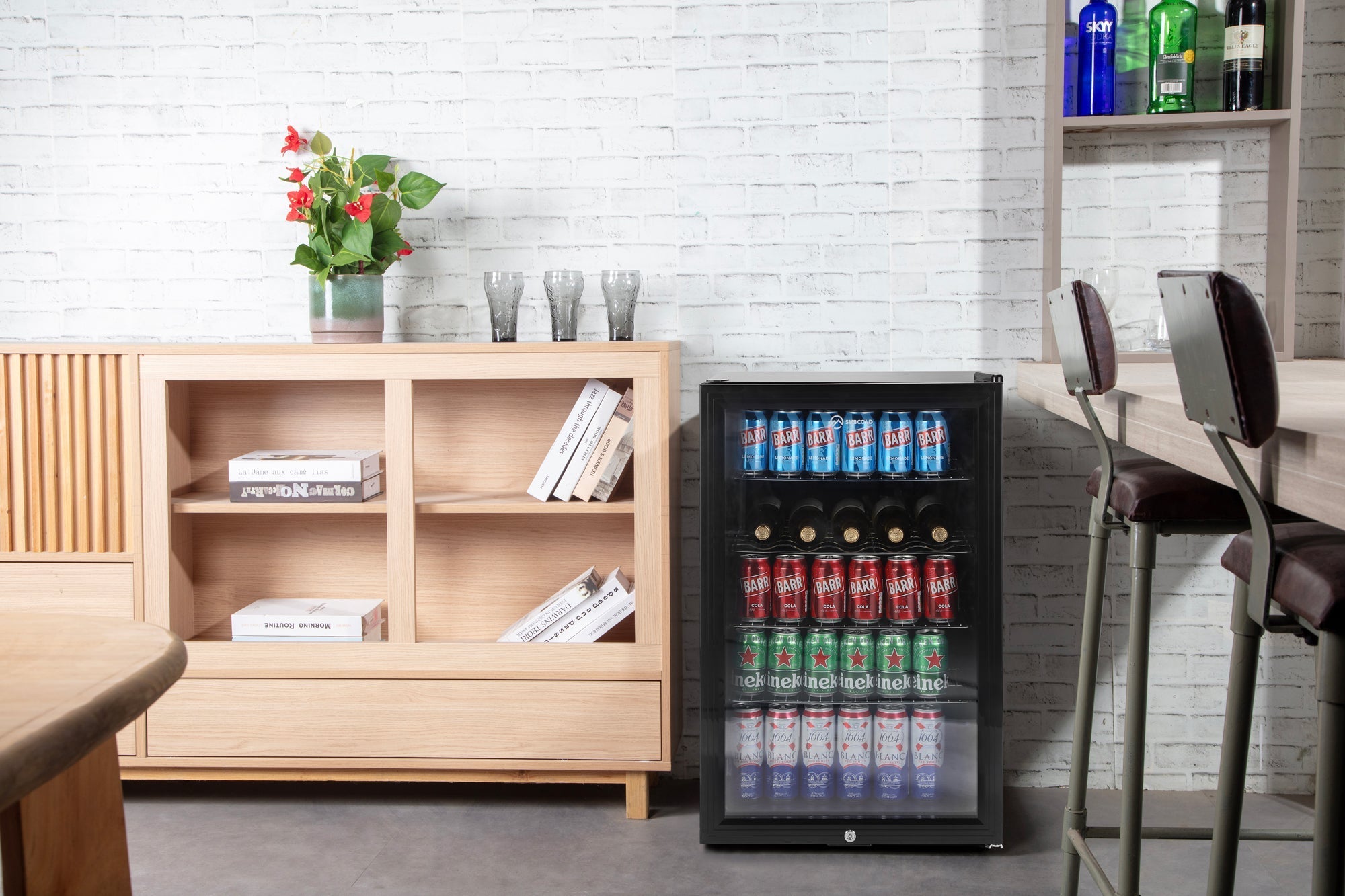 Black glass-door subcold super led beer fridge filled with assorted cans and bottles for beverage storage