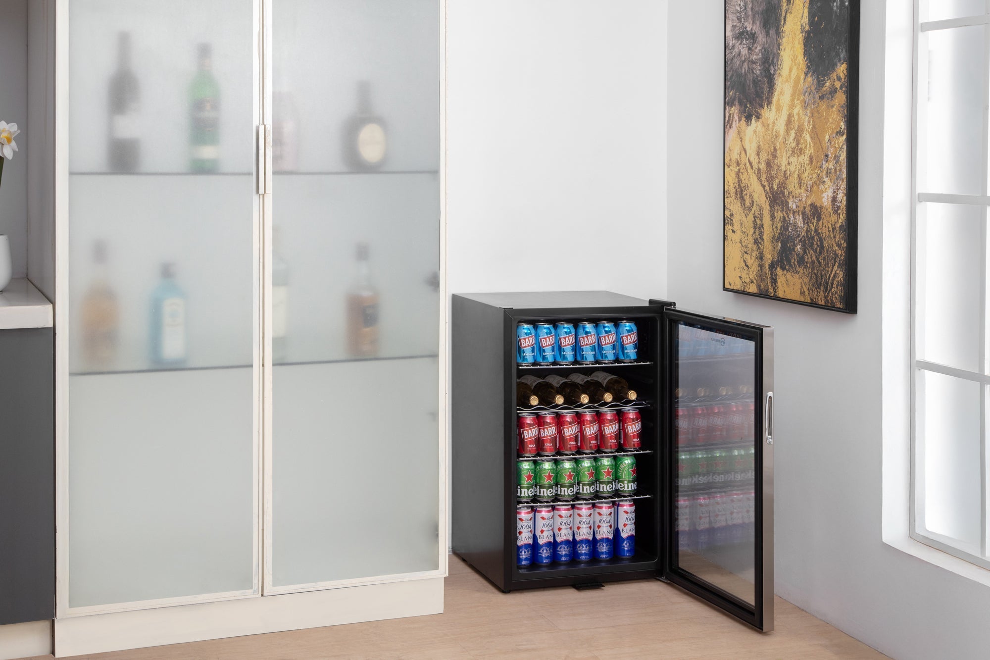Black and stainless steel subcold super led beer fridge with glass door stocked with colorful sodas and wine bottles