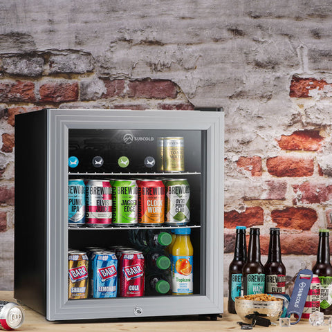 Subcold super50 led beer fridge with silver frame black body and glass door stocked with colorful canned drinks fridge