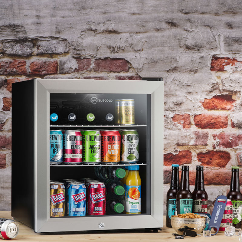 Silver framed subcold super50 led beer fridge with glass door and black shelves stocked with colorful drinks fridge cans