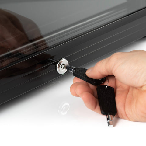 Black key with silver lock being inserted into sleek dark gray subcold super65 drinks fridge for secure access