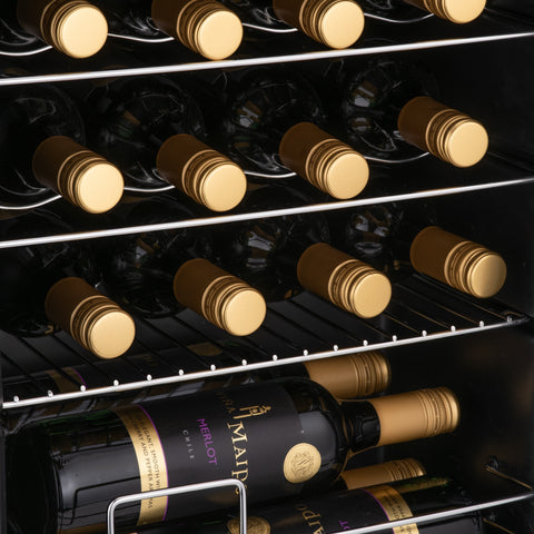 Black wine bottles with gold foil neatly stored inside a modern subcold viva24 led wine cooler fridge