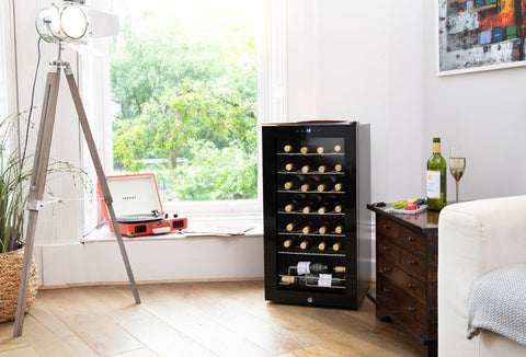 Black glass door subcold viva28 led wine cooler with multiple shelves holding bottles in a wine fridge