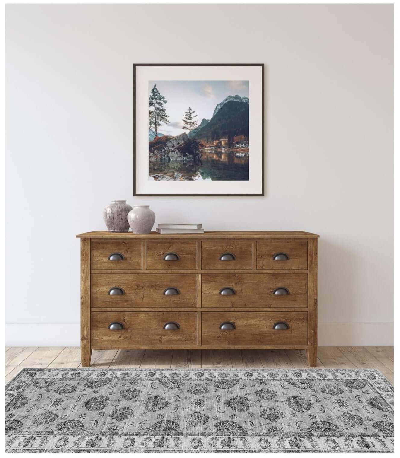 A rustic wooden dresser with nine drawers and dark metal handles paired with sulus vintage washable rug