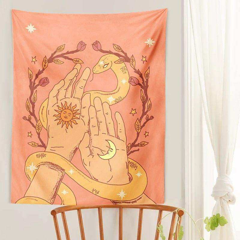 A soft peach-colored moon tapestry featuring hands with sun and moon design wrapped by a golden snake and stars