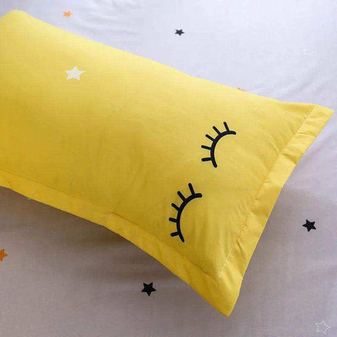 Bright yellow pillowcase with embroidered black closed eyes and white star made of soft fabric for flat bed or duvet cover