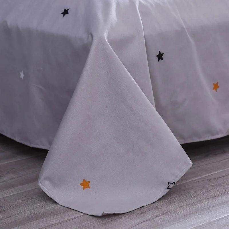 Light gray cotton bed skirt with black white and orange embroidered stars for sun & stars duvet cover set