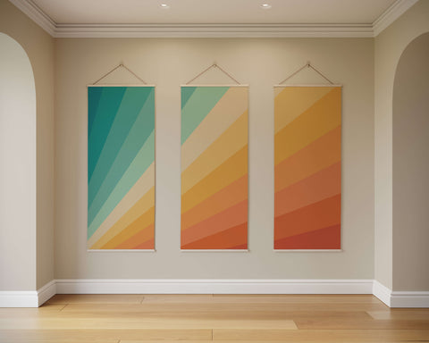 Three vertical canvas art panels with vibrant teal and orange diagonal stripes in the sunbeam tapestry design