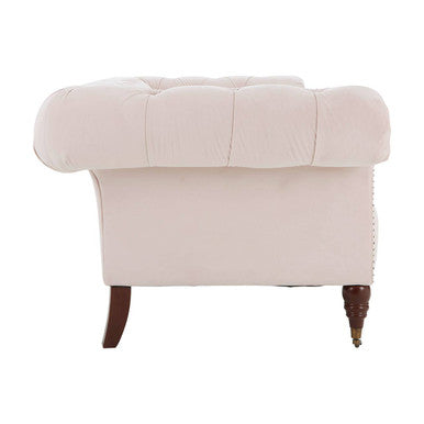Cream-colored tufted velvet armchair with dark larch wood legs complementing blossom fabric chesterfield sofa