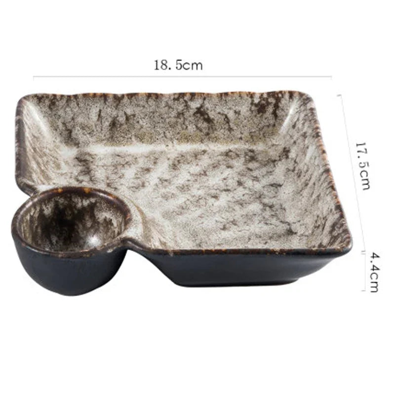A rustic ceramic sutekina plates serving tray with speckled gray and black glaze and a built in small bowl on one side