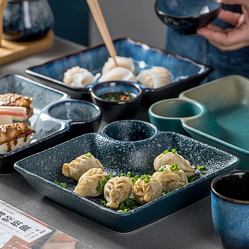 Dark blue speckled ceramic sutekina plates with a recessed well holding steamed dumplings garnished with green onions