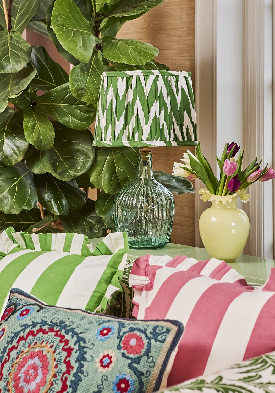 Green and white zigzag lampshade on textured green glass bottle paired with Suzani rectangle cushion covers