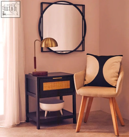 Black-framed circular mirror with geometric double-layered design next to sydnee wood base brass finish task lamp